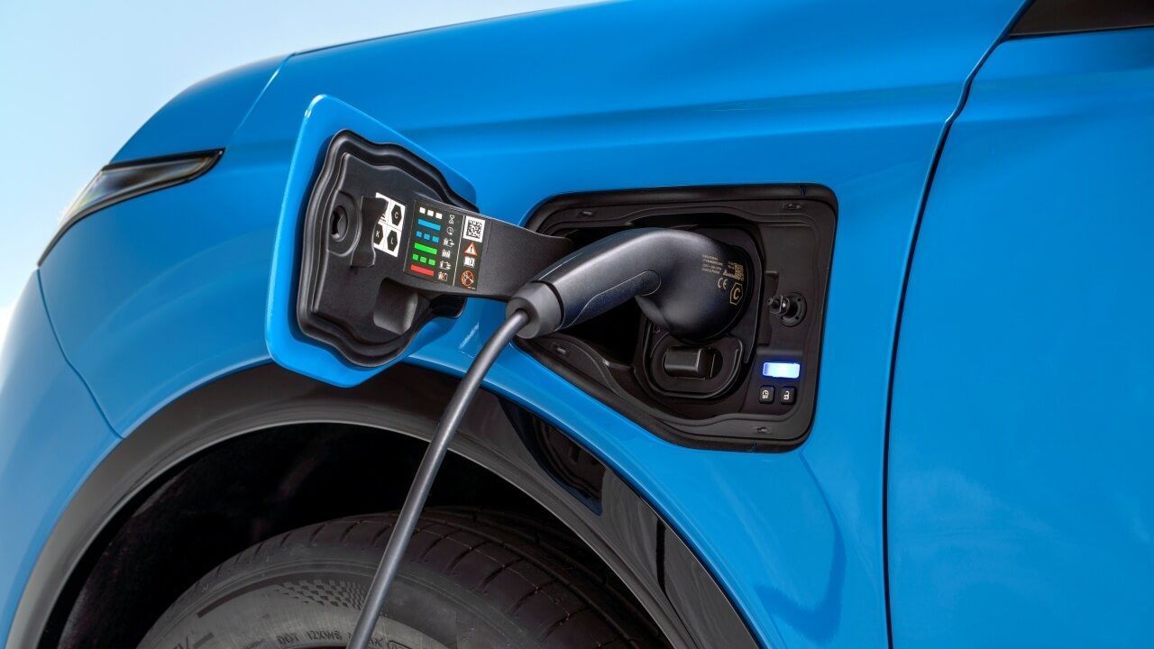 detailed-shot-of-open-electric-charging-port-with-a-charger-plugged-in-on-left-side-above-the-wheels