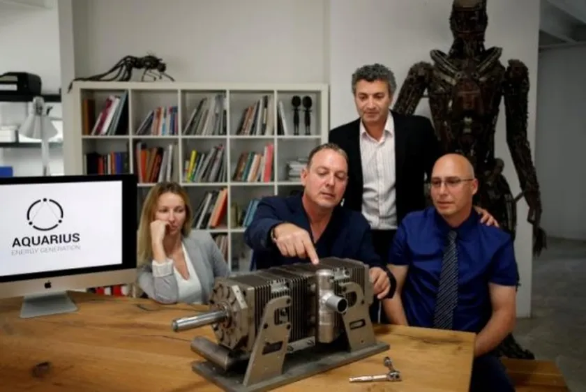 Shaul Yaakoby (R), CTO and Inventor, Gal Fridman (C), Chief Marketing Officer, Maya Gonik (L), Head of Business Development and Ariel Gorfung (standing), Chief Executive Officer from Israeli start-up Aquarius Engines pose for a picture next to a prototype of their combustion engine at their offices in Rosh Ha'ayin, Israel May 16, 2016. REUTERS/Amir Cohen